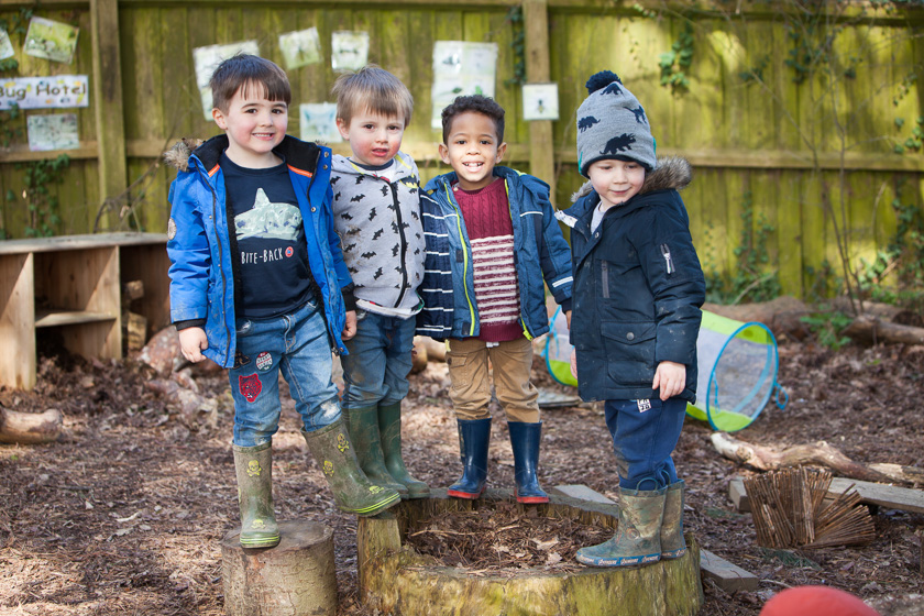 Four children standing on tree trunk